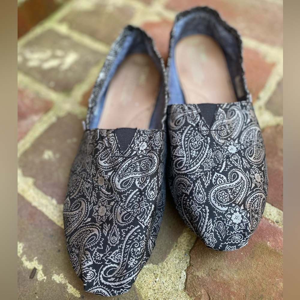 Toms brand Women’s Flats. Size 9.5W. Black and silver paisley pattern.